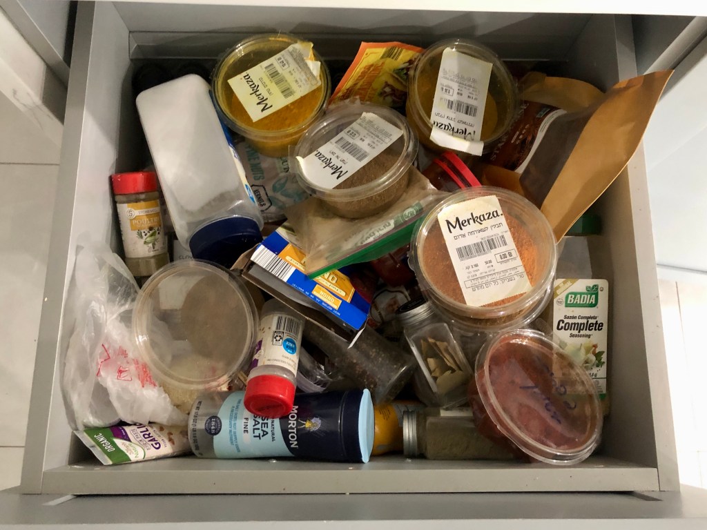 Spice drawer organization with labeled jars and tiered spice shelves. Professional organizer Palm Beach County. Home organization services Palm Beach County. 